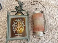 Two vintage lamps placed on carpet; one square with intricate metal and etched glass design, the other cylindrical with pink textured glass, showing wiring and missing screw finials.