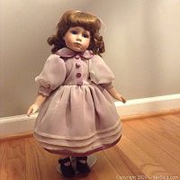 Full view of the 15-inch tall Seymour Mann porcelain doll standing on a metal display stand.