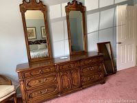 Front view of the Thomasville triple dresser with two large ornate removable mirrors, showing drawer details and brass hardware