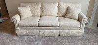 Full front view of three-seat sofa with cushions and throw pillows