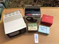 Lot contents overview with portable TV and boxes of viewers and reels.