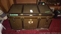 Front view of the vintage storage chest measuring approx 39x19x21 inches with metal reinforcements and lock hardware.