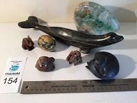 Wide view of all seven carvings with ruler for scale