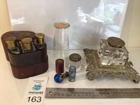 Set of various small glass items including inkwells, specimen jar, perfume bottle shown together with tag and ruler for size reference