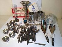 All items in the lot arranged for overview shot showing steins, flatware, bowls, coasters, and decorative pieces.