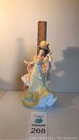 Front view of Royal Doulton 'Flowers Of Love C' figurine beside ruler showing 9 inch height.
