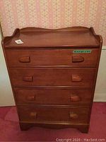 Front view of Vilas wooden dresser showing 4 drawers and sculpted handles with carving detail on top backboard.