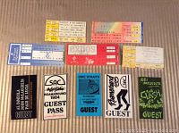 Photo showing variety of ticket stubs including guest passes from SAC 1984, Dire Straits guest pass, Clash guest pass, and other vintage printed tickets.