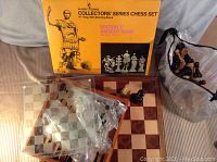 Image of the Classic Games Collectors' Series Chess Set Edition I Ancient Rome box, the wooden chessboard, and a plastic chessboard, with chess pieces visible.