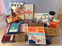Photo showing assortment of vintage board games and puzzles with original boxes including Qubic, Switch, The Viking Leprechaun, Multipuzzle, and wooden pegboard games.