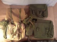 Three canvas backpacks laid out flat showing fronts and backs