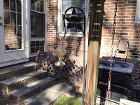 Patio area with glass hummingbird feeder hanging and metal wall star visible