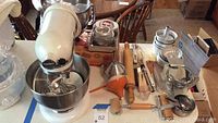 Overview of stand mixer on tabletop with bowls, attachments, and baking tools arranged around it
