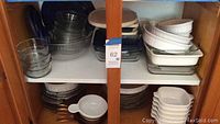 Photo of shelves showing stacked clear glass Pyrex bakeware, nested white bowls, and white Corningware dishes with lids.