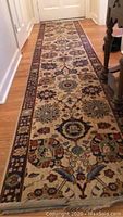 Long floral patterned runner on wooden floor, maroon and beige with blue accents