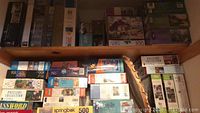 Two shelves loaded with assorted puzzle boxes