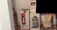 Various boxed and unboxed Christmas decoration items including nativity and porcelain church building.