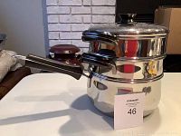 Stacked view of all components of the Lagostina cookware set, showing the long handled pot with lids and inserts stacked on top.