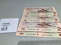 Five 1986 Canadian two dollar banknotes front side with bird design visible and serial numbers