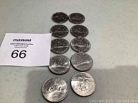 Top-down view showing the front face designs of ten Canadian silver $10 coins arranged in a shape on a grey surface.