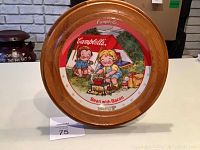 Full view of the framed decorative Campbell Kids plate featuring Bean With Bacon Soup design set against white background.