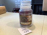 Front view of a large Yankee Candle jar with lavender vanilla label, placed on a table.