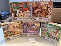 Photo showing all five puzzle boxes stacked together displaying colorful artwork of different themes.