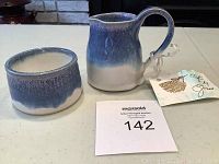Photo showing ceramic creamer jug and sugar bowl with blue to white gradient glaze on a table, tagged with auction lot number.