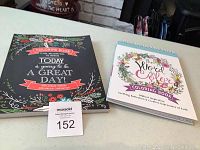 Two new inspirational adult colouring books displayed on table to show front covers.