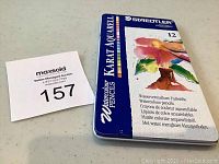 Closed blue metal tin of Staedtler Karat Aquarell watercolour pencils with branding and product information on the lid.