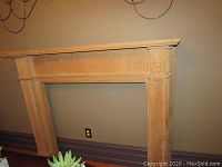 Full frontal view of the solid wood mantel against wall