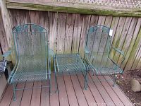 Front view of both chairs and connecting side table on deck in front of wooden fence
