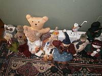 Full lot of assorted plush toys and holiday decor arranged sitting on a carpet, showing variety and quantity of items