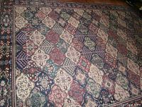 Photo showing full view of the patterned large rug on wooden floor.