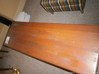 Top view of the solid wood sofa table showing the rectangular surface with minor scratches and visible wood grain.