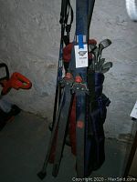Photo of skis and golf clubs leaning against a wall in basement area