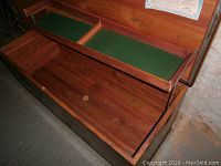 Open cedar chest displaying interior compartments and cedar wood storage area