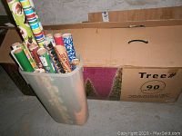 Plastic bin with multiple rolls of Christmas-themed wrapping paper shows variety of colors and patterns including green, red, blue, and brown.