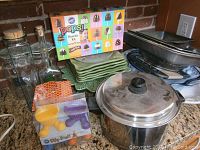 Wide view of collection showing glass bottles, Wilton Pops Brownie Kit, green plates, baking pans, and stockpot