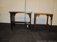 Front view of two small wooden side tables, showing overall shape and style