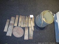 Photo of two wooden buckets, one disassembled into multiple wooden pieces, the other assembled but worn.