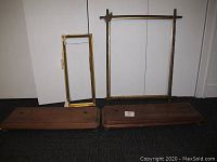 Two wooden frames and two stand bases displayed together on floor, showing size and condition
