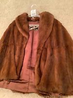 Front view of the vintage brown fur coat showing its texture and lining