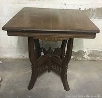 Front and top view of antique wooden parlour table showing rectangular top and carved legs with base stretcher.