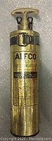 Photo of the vintage ALFCO VL-1 fire extinguisher showing full front, brass body, and top handle with locking strap.