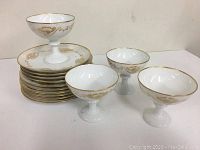 Lot of vintage Rosenthal porcelain dishes including small pedestal dessert bowls and matching plates with gold trim and floral design.