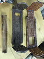 Photo showing two expandable wooden carved bookends and one long wooden incense burner, placed on wooden table.