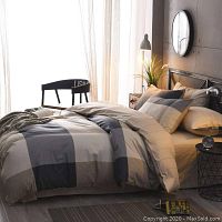 Styled bed showing duvet cover on queen bed with pillows and bedside decor