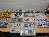 Top-down view of assortment of license plates showing Nevada, California, Arizona, Washington, and Ohio plates on a table.