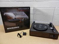 Turntable and box with power adapter included, showing packaging and unit from the front angle.